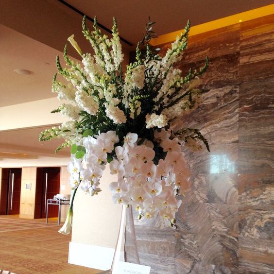Tall white ceremony arrangement with orchids and snapdragons